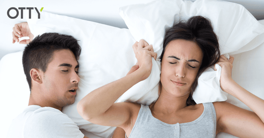couple in bed where the woman is struggling to get to sleep because her partner is snoring, sleping soundly on the hybrid mattress