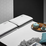 a pair of memory foam pillows on top of our hybrid mattress with a rather nice looking pastry, cup of tea and teapot on a tray laying on the bed as well 