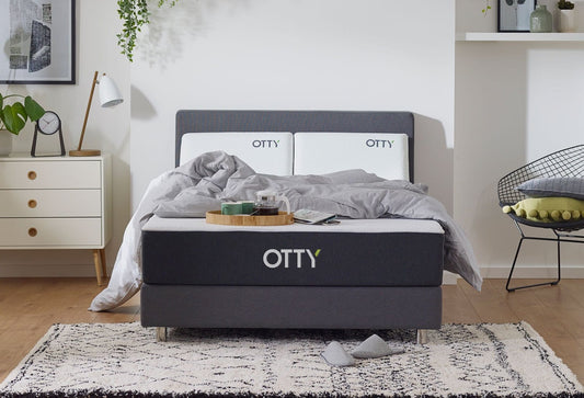 The OTTY refreshed hybrid mattress has been re-covered and steam cleaned to ensure full hygiene is restored. Mattress is in a bedroom setting with a duvet placed on top. 