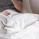 image of our duvet cover on a bed with a couple enjoying how soft the white bedding is.
