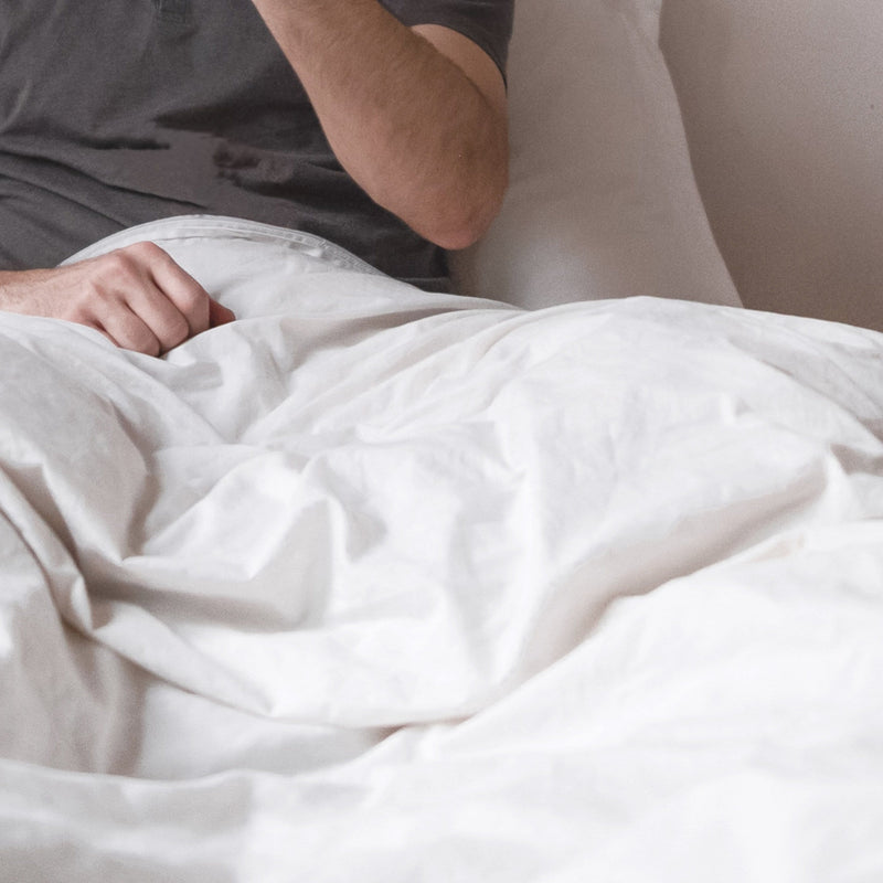 image of our duvet cover on a bed with a couple enjoying how soft the white bedding is.